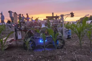 Polní robot a lidé při soutěži za soumraku